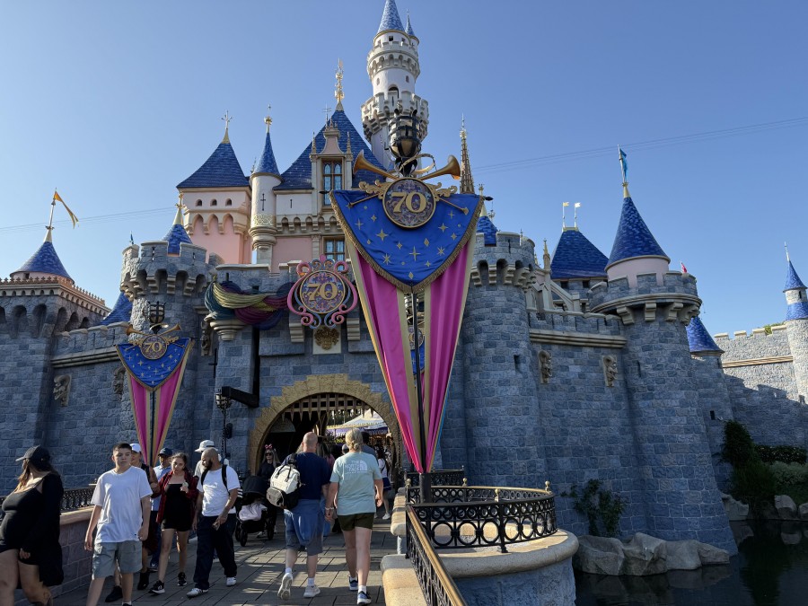 A 50-foot castle sculpture and colorful banners welcome guests to Disneyland’s vibrant 70th Anniversary celebration.