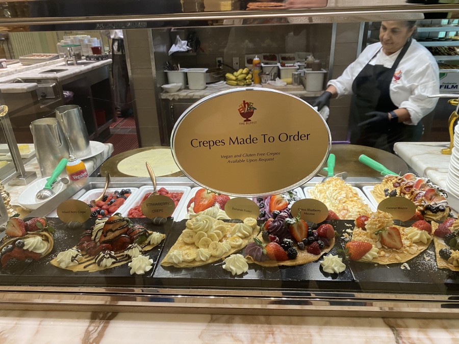 A vibrant buffet dessert station displays rows of rich chocolate cakes, colorful pastries, and sweet treats - offering a tempting dessert for every taste.