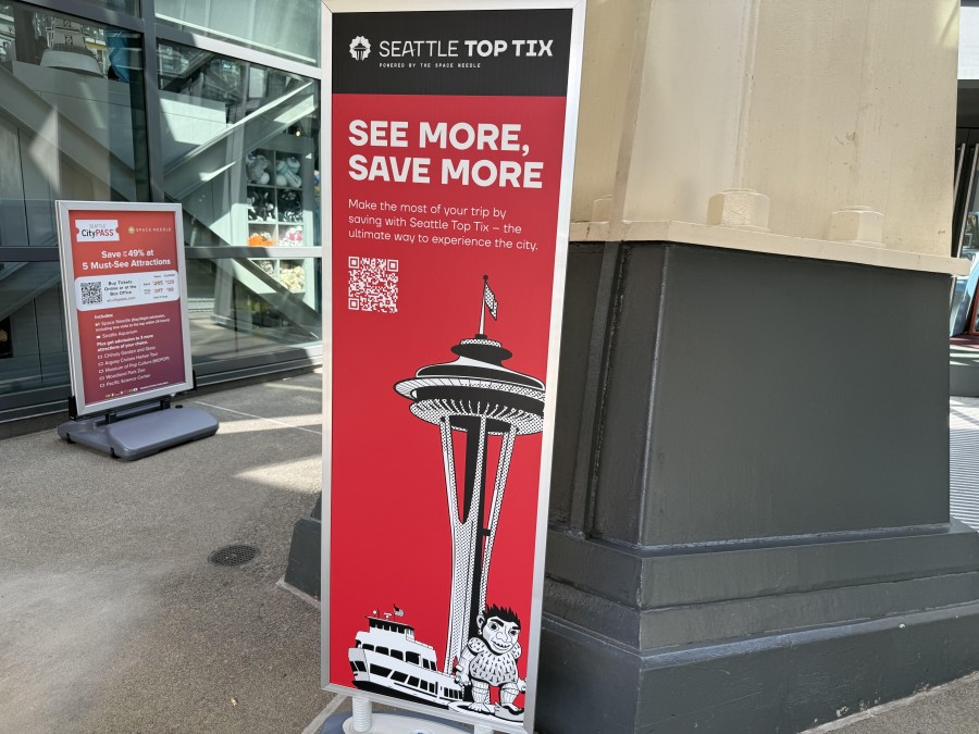 Visitors enjoy panoramic city views from the Space Needle's glass deck.