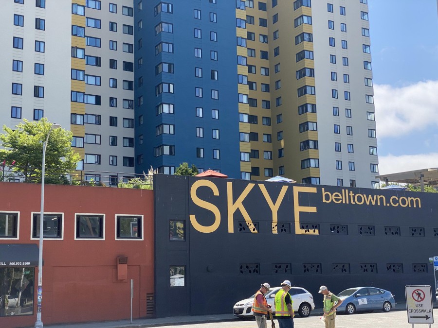 Guests relax at Skye at Belltown, a modern rooftop lounge offering stylish seating, ambient lighting, and stunning views of the nearby Space Needle