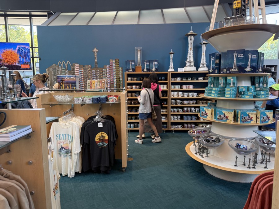 Inside the Space Needle’s souvenir store, visitors browse a vibrant collection of Seattle-themed merchandise, including mini Space Needle models