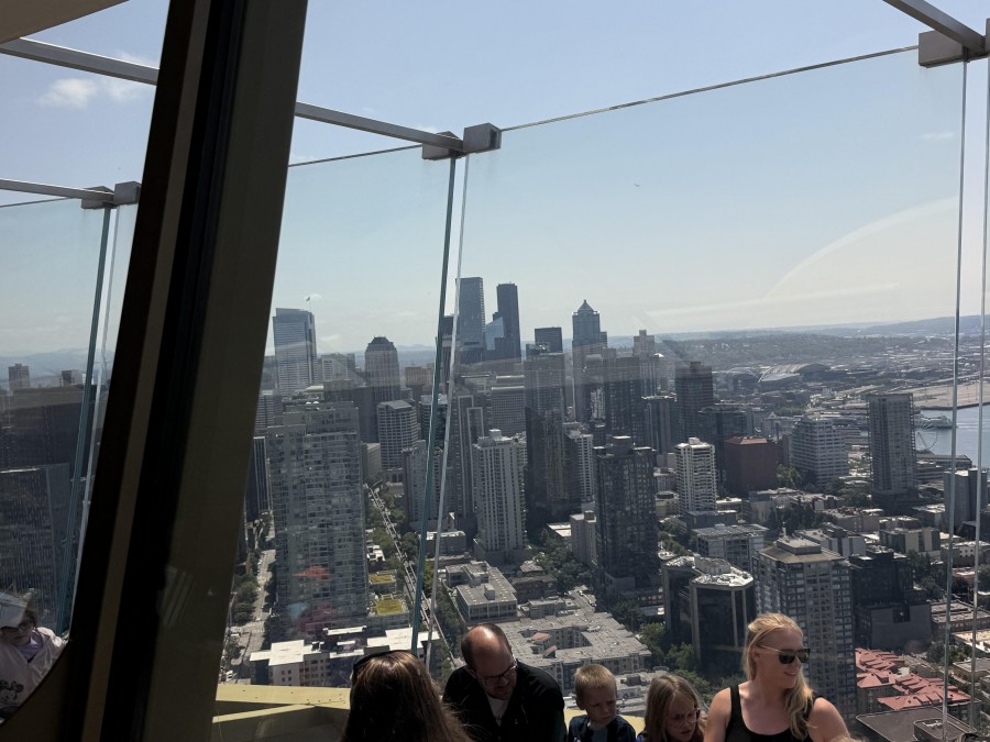 Visitors enjoy panoramic city views from the Space Needle's glass deck.