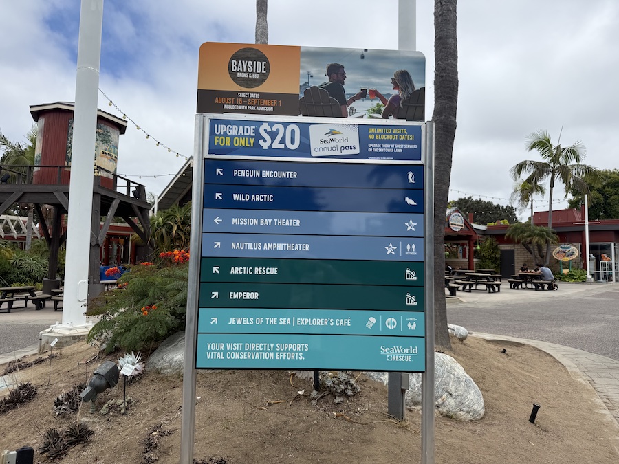 Directional signpost at SeaWorld San Diego pointing to popular attractions.