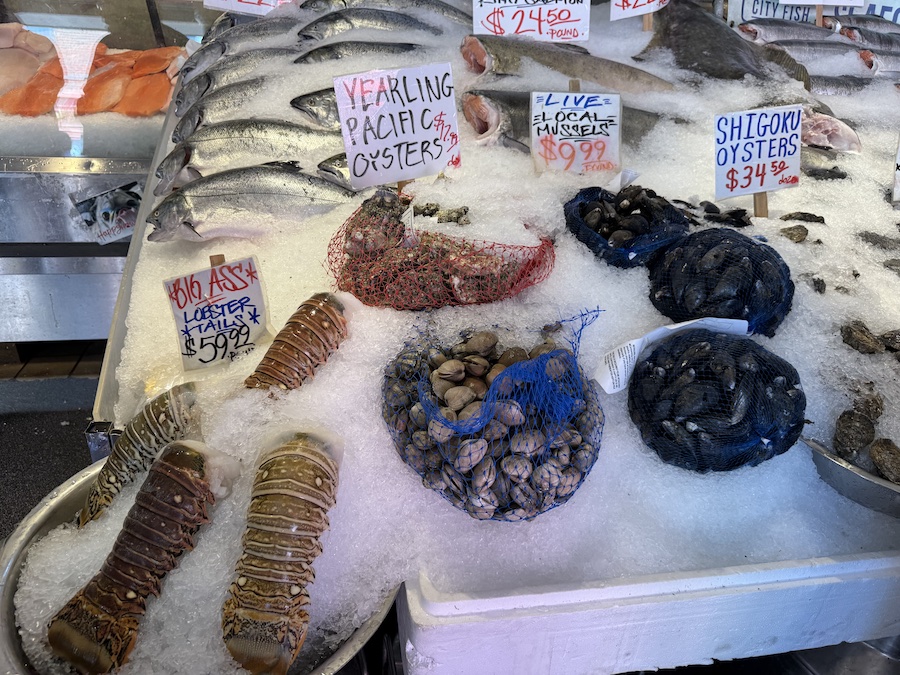 A colorful seafood display featuring lobster tails, clams, and scallops.