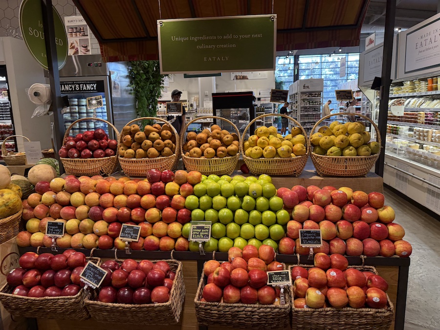 Fresh apples neatly stacked in rustic wooden crates among produce.