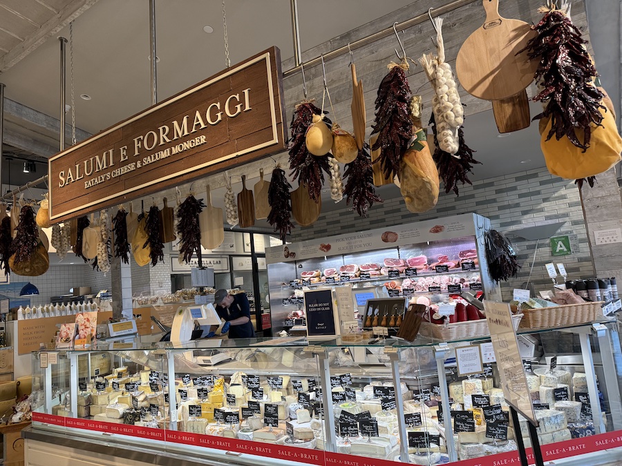A stall filled with Italian cured meats and aged cheeses at Eataly LA .