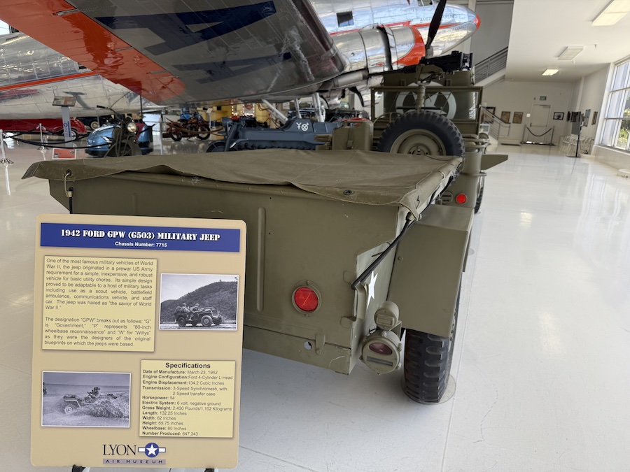 Restored WWII-era military Jeep in olive drab on display.