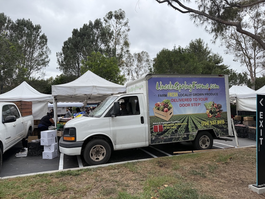 Car with Lincoln Spring Farms logo parked beside the market stall.