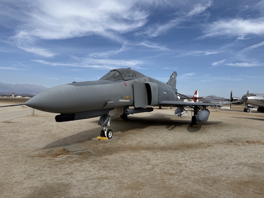 A gray McDonnell Douglas F-4 Phantom II fighter jet is parked outdoors.