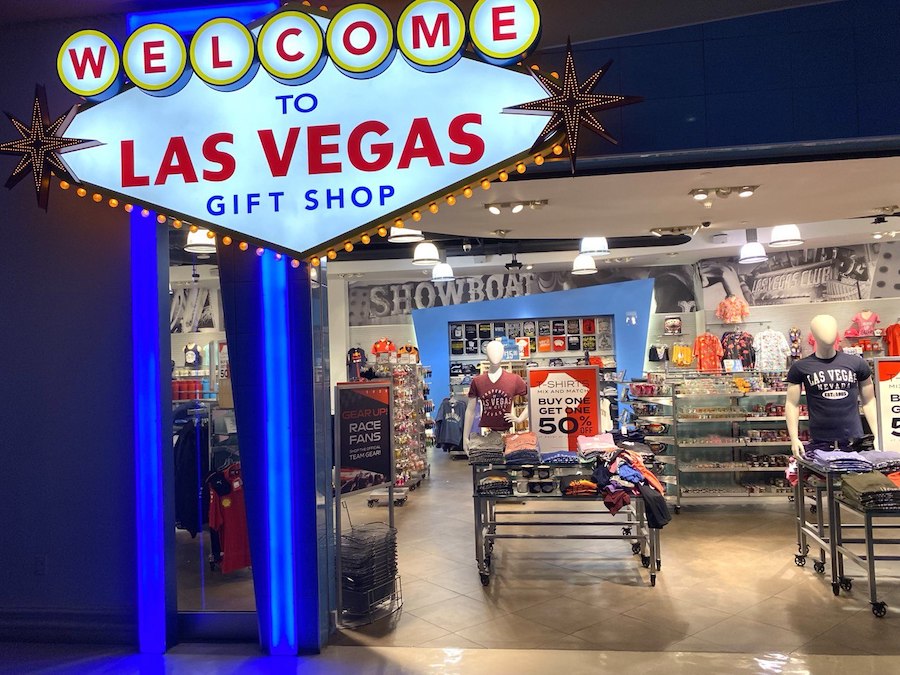 Colorful gift shop display inside The Venetian with Las Vegas souvenirs, mugs, and T-shirts neatly arranged on shelves.