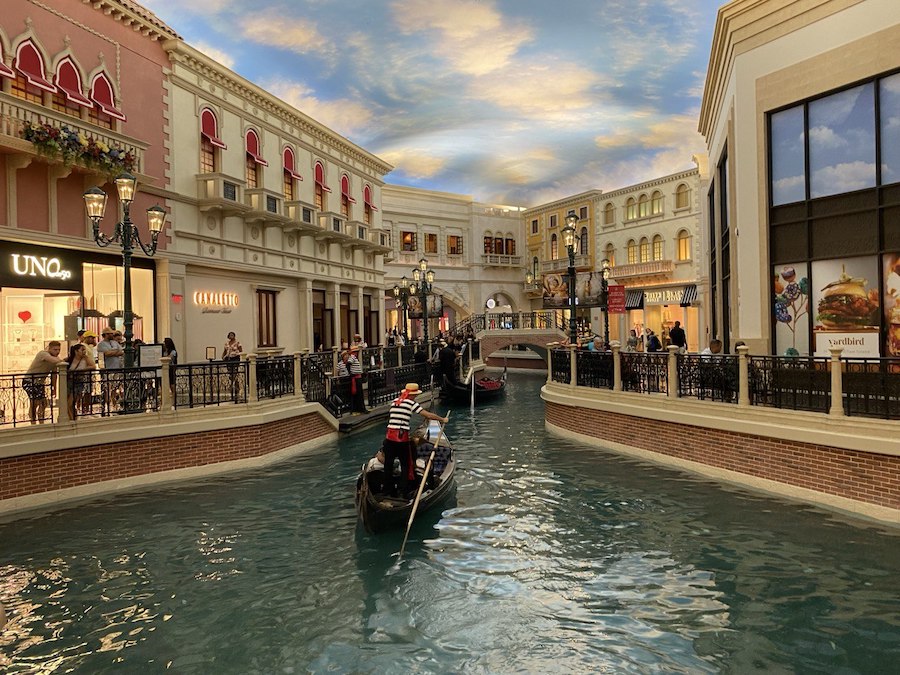 A gondolier rows visitors through the Grand Canal at The Venetian, recreating Venice's charm indoors.