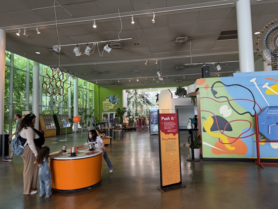 Kids exploring a hands-on science experiment in a bright exhibit hall.