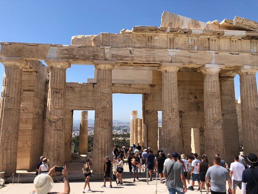 Visitors admiring the Acropolis Museum with the ancient landmark in the background.