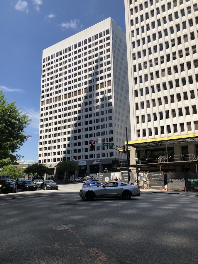 A lively mixed-use destination with modern architecture, outdoor dining, and bustling urban energy.