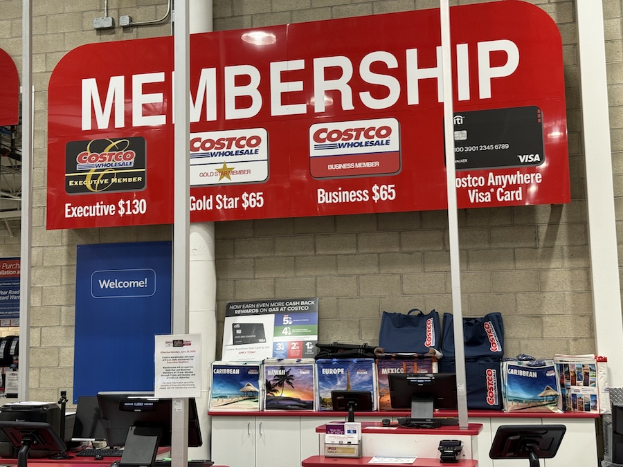Sign promoting Costco membership benefits inside the store.