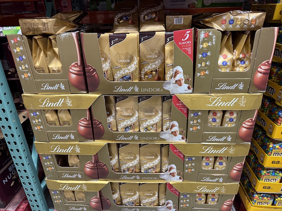 Rows of assorted chocolate gift boxes stacked high at Costco.