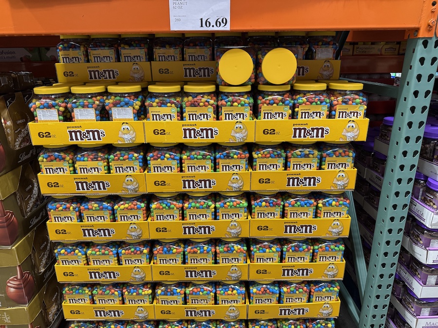 Variety of M&M’s packages, from peanut to classic, displayed in Costco aisles.
