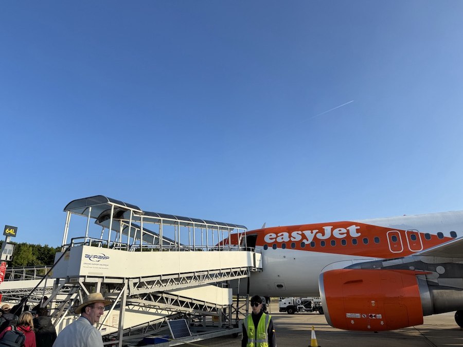 A bright orange EasyJet plane accepts passengers.