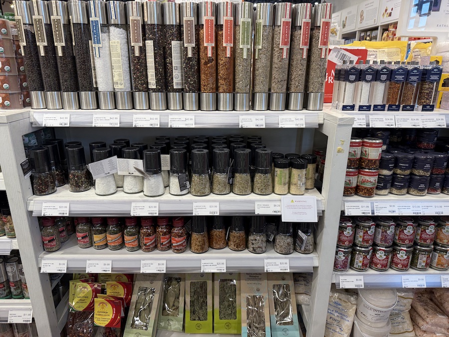 Elegant glass jars of IL Boschetto spices with rustic Italian labels.