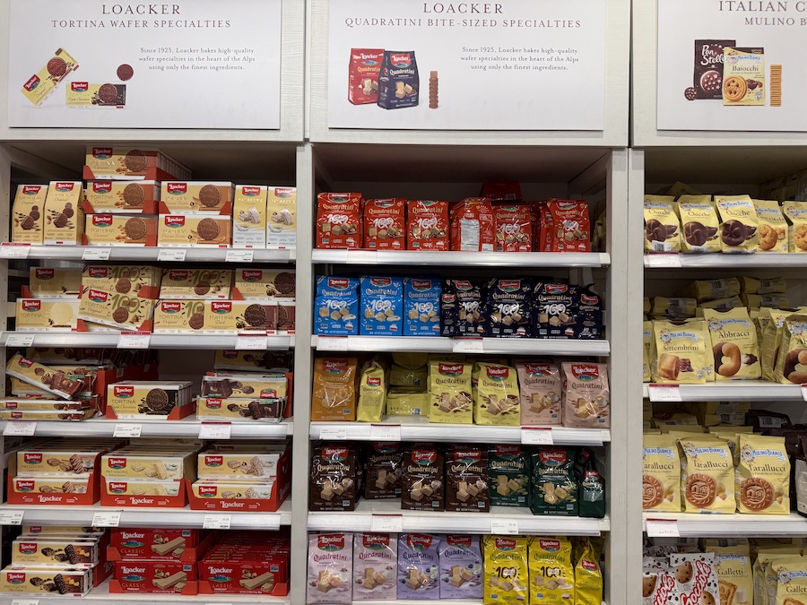 A colorful display of Loacker wafer packages stacked neatly on Eataly shelves.
