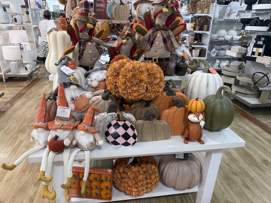 Seasonal shelves mixing fall harvest and Halloween decor.