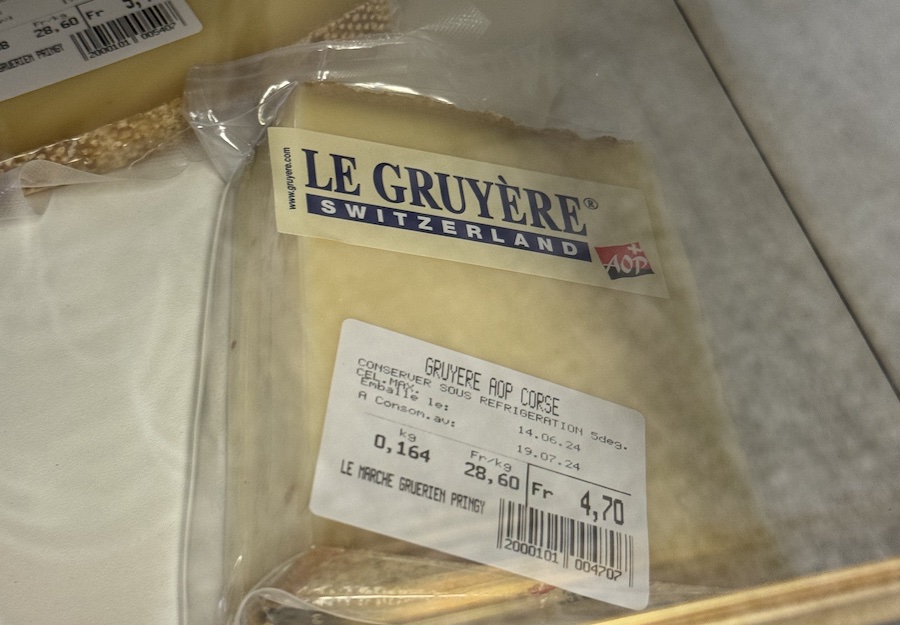 A piece of fresh cheese on a store shelf.