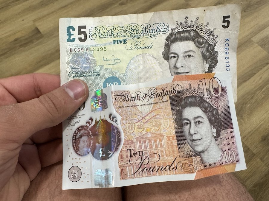 A tourist holds British pound notes.