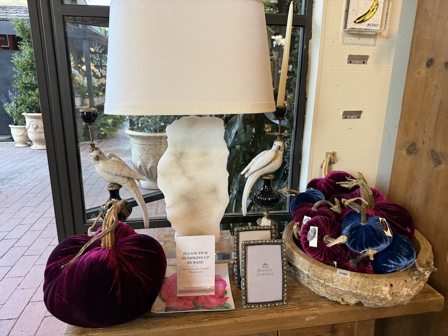Plush soft pumpkins in fabric and velvet textures stacked in a basket.