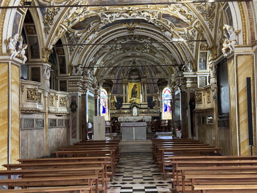 Interior shot of Madonna del Sasso with ornate frescoes and golden altar.