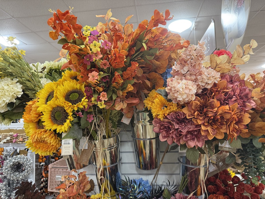 A colorful arrangement of fall-themed faux flowers is on display.