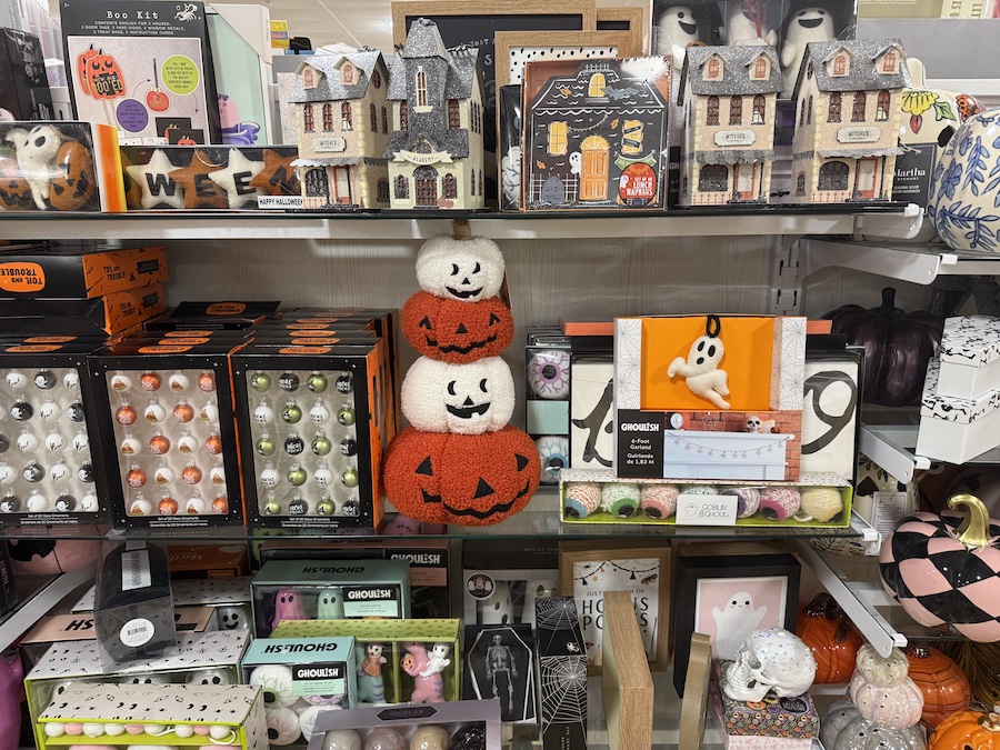 A shelf is dedicated to Halloween decorations, including a collection of small, lighted haunted houses and an assortment of ornaments.