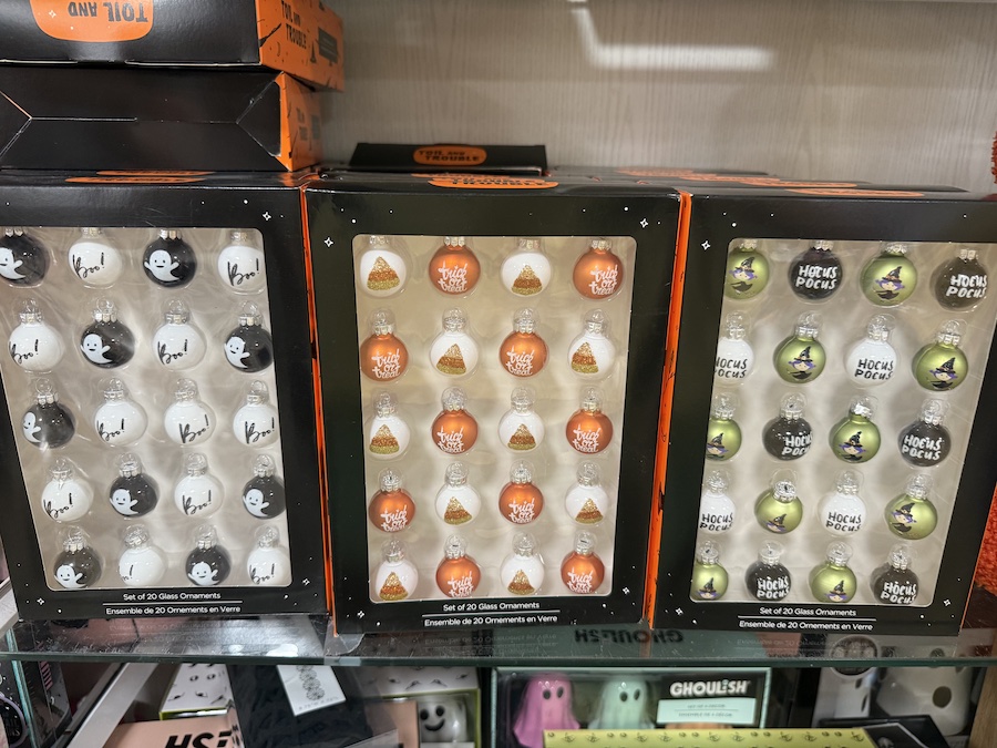 A display of boxed glass ornaments showcases three different Halloween themes.