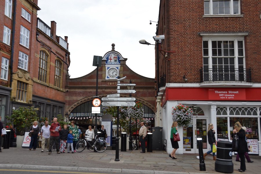 Street view in Windsor with a clock tower and signs to various local attractions in the center.