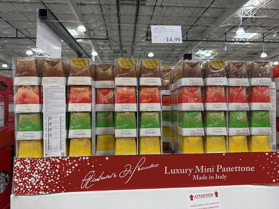 Colorful assortment of mini Italian panettone cakes in festive wrappers.