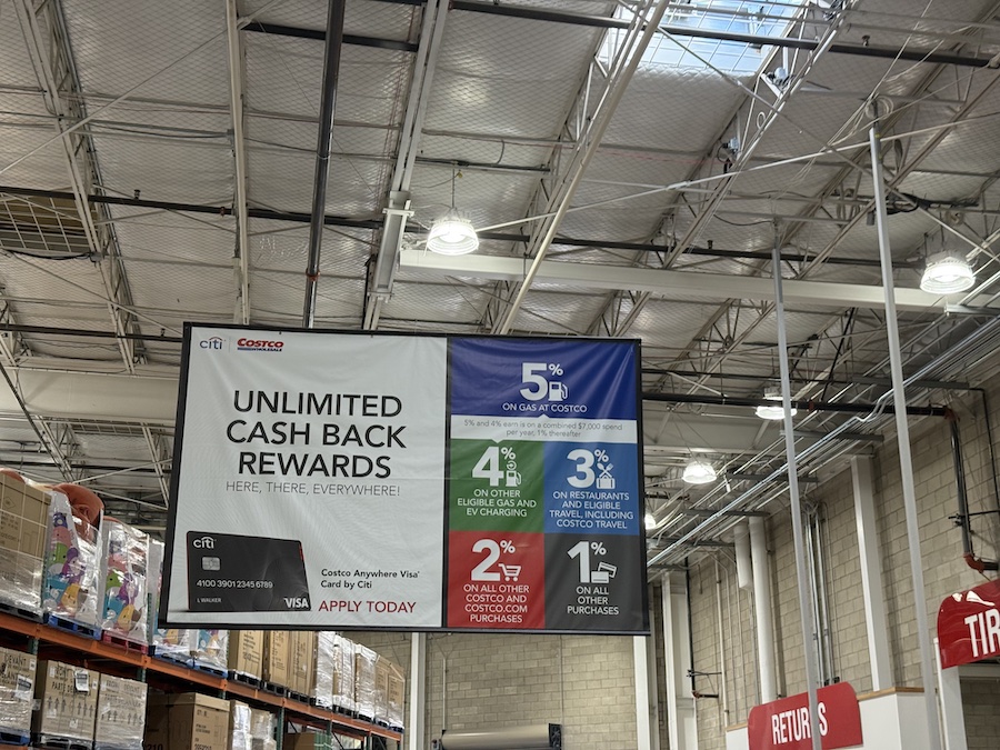 A Costco credit card promotion display showing “Unlimited Cash Back Rewards” signage.