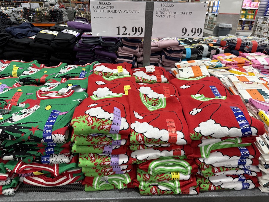 Character Youth Holiday Sweaters on racks in the clothing section with festive signage.