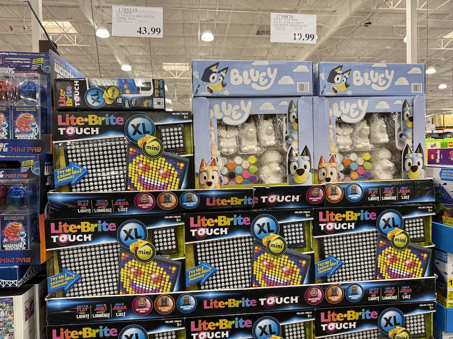 Brightly lit Costco aisle filled with educational and creative toys, including the Lite-Brite Touch XL & Mini Touch Combo Pack.