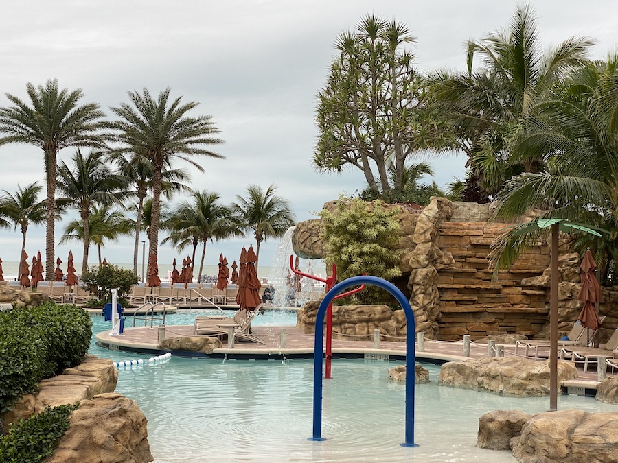A wide shot of a large, lagoon-style outdoor pool area. 
