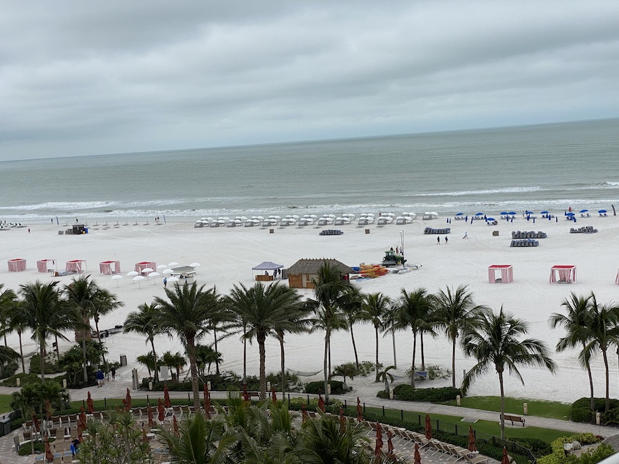Colorful beach umbrellas and lounge chairs line the wide stretch of sand in front of the JW Marriott resort.