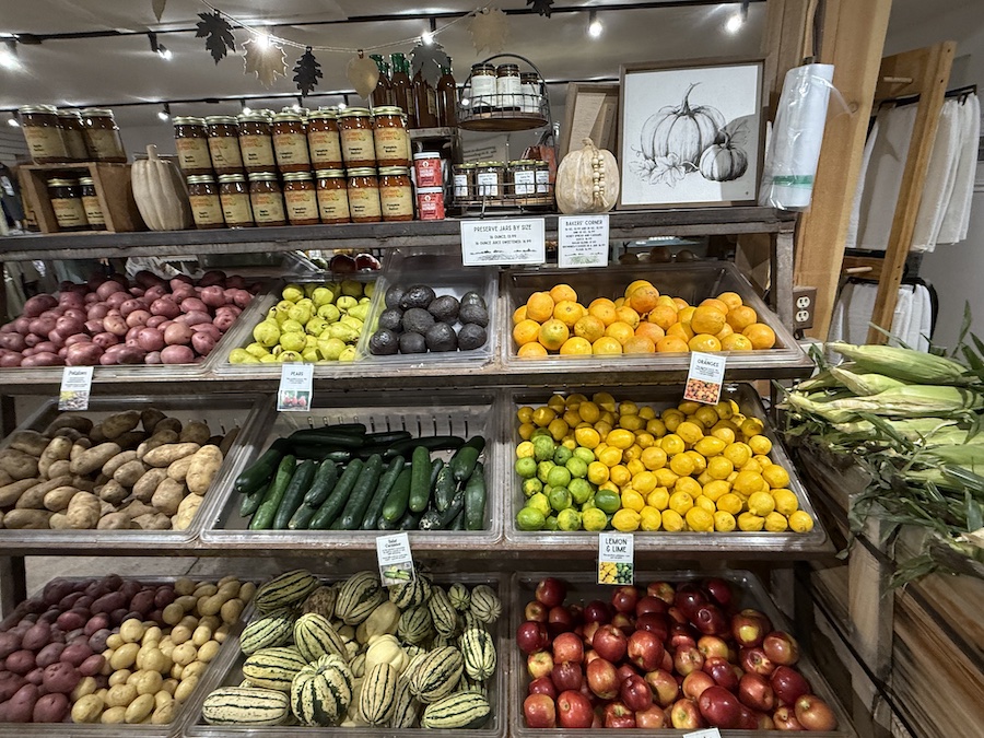 Fresh fruits and vegetables stacked in wooden crates inside the market.
