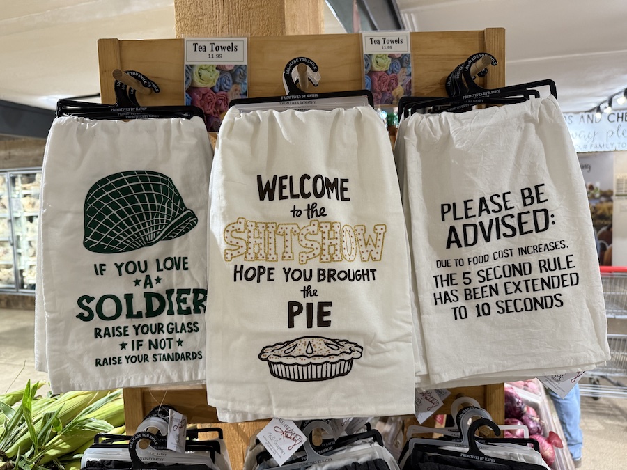 Souvenir corner featuring tea towels, mugs, and farm-branded gifts.