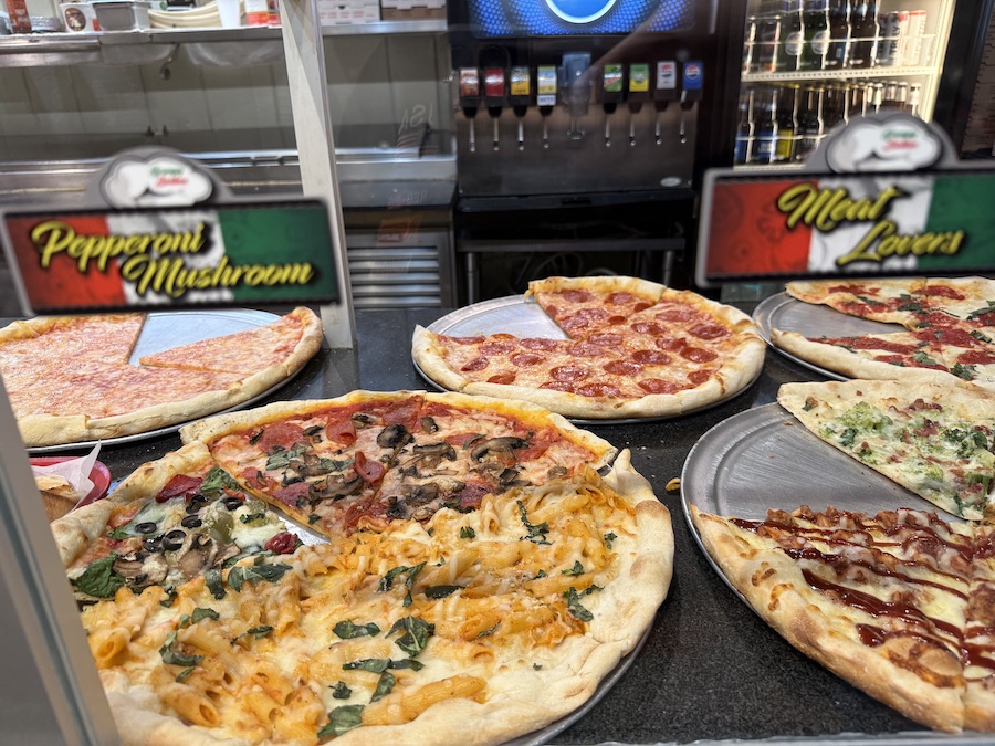 Freshly baked pizza on a plate at Limoncello Pizzeria Napoletana, topped with basil, mozzarella, and tomato sauce.