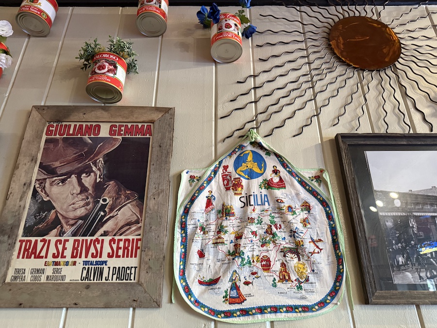 Interior shot showing framed pizza-themed artwork and neon signs that add a fun, urban touch.