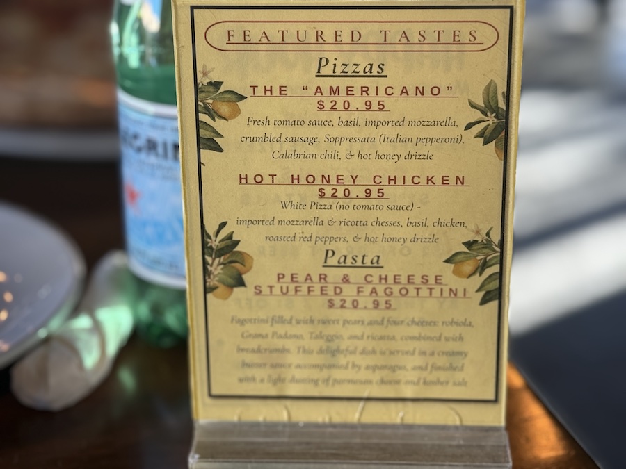 Limoncello Pizzeria Napoletana menu displayed on a wooden table, highlighting authentic Italian specialties.