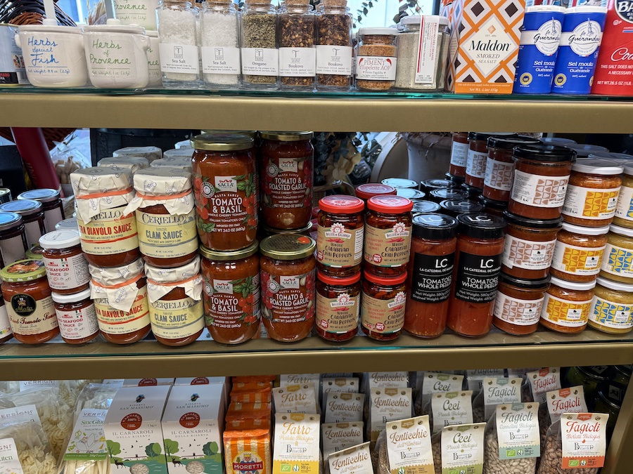 Display of pasta sauces and spices in elegant packaging.
