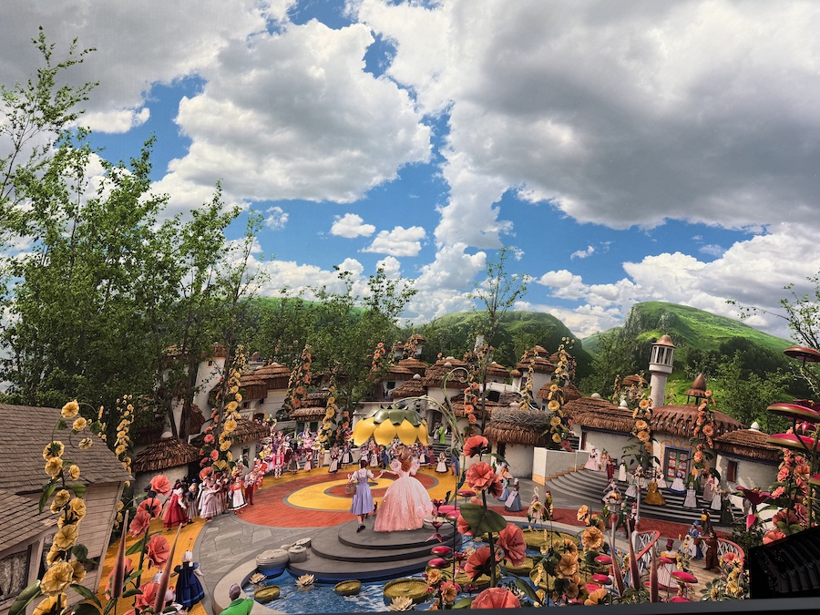 A wide, immersive, and highly detailed digital screen display showing the colorful world of Munchkinland.