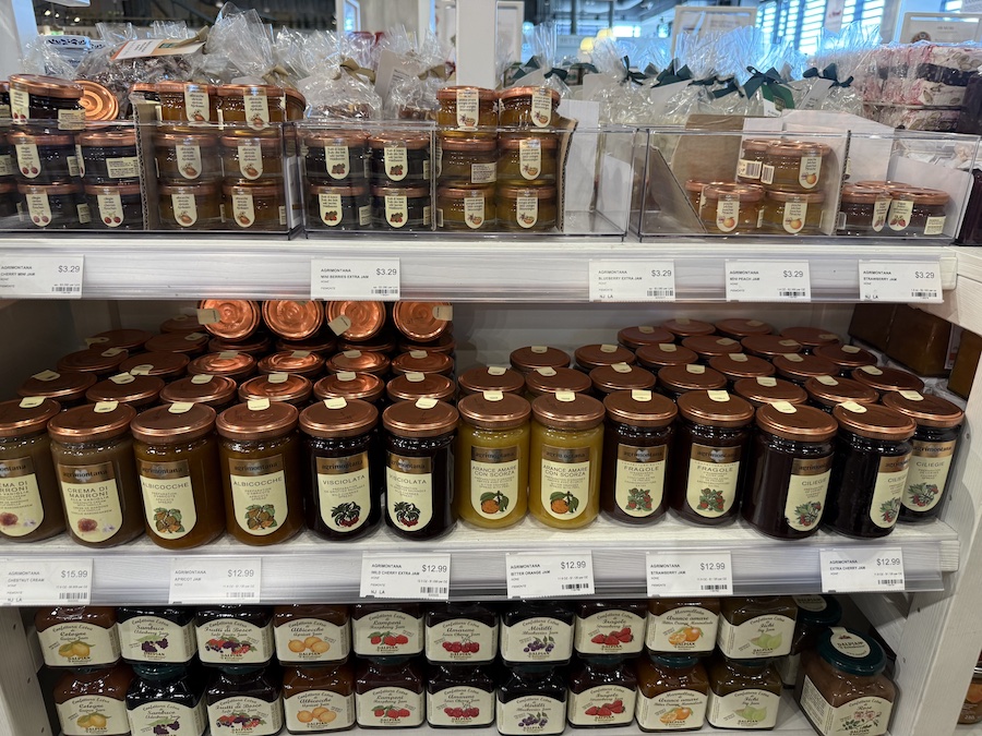 Artisanal Italian fruit preserves neatly arranged on shelves.