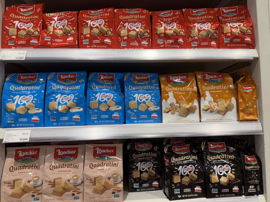 Neatly stacked bite-sized Italian wafer cubes in assorted flavors, including hazelnut, vanilla, and chocolate, displayed on shelves at Eataly LA.