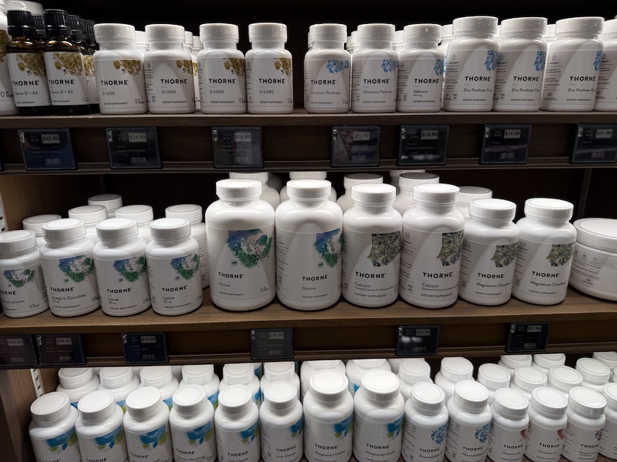 Full shelf dedicated to Thorne’s dietary supplements, featuring capsules, powders, and wellness blends in clean minimalist packaging.