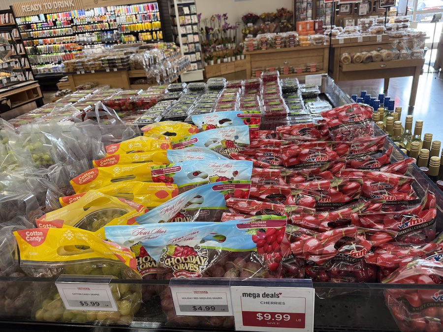 Lush red and green grapes and plump cherries arranged beautifully in the fruit display.